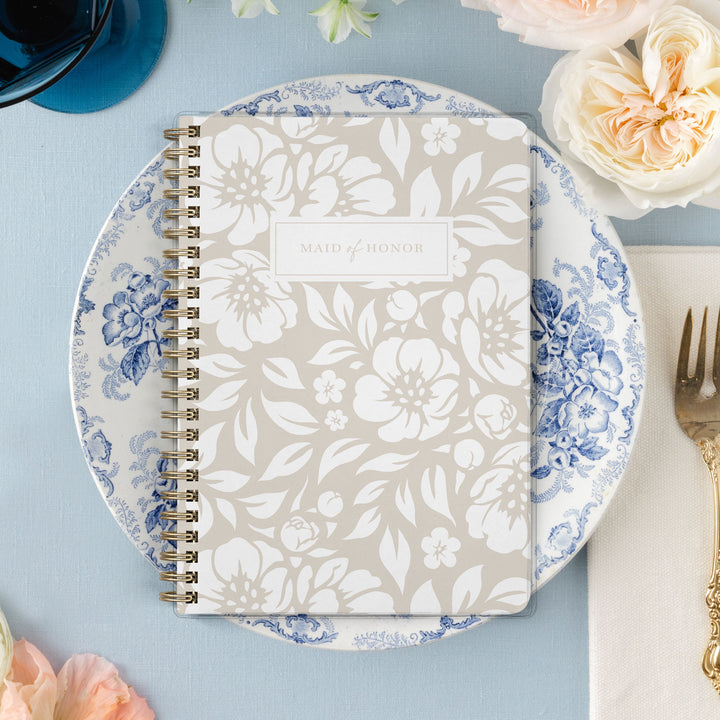 Our exclusive maid of honor planners are the perfect gift for your best friend, shown in a neutral beige floral design.