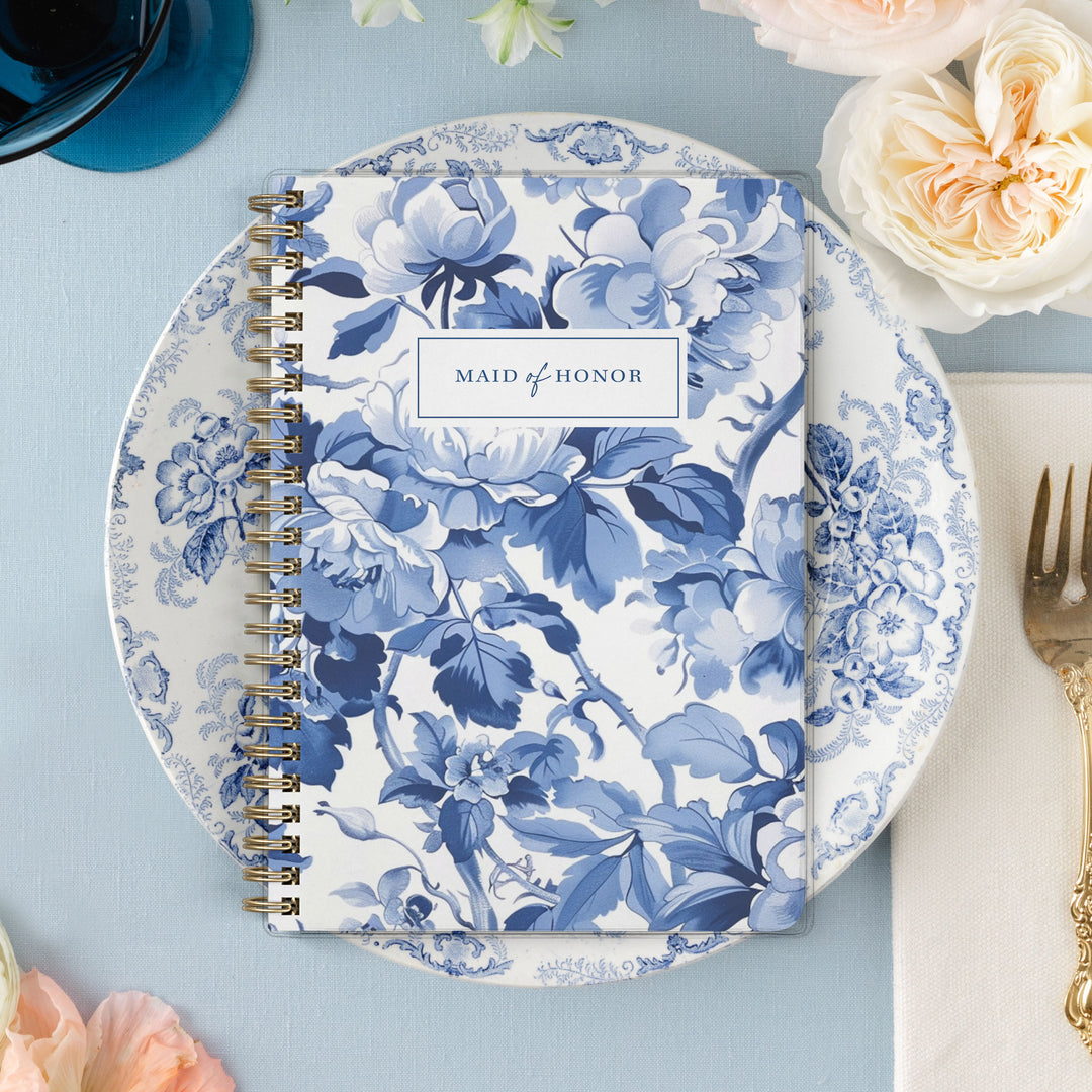 Our exclusive maid of honor planners are the perfect gift for your best friend, shown in a blue toile cabbage rose print