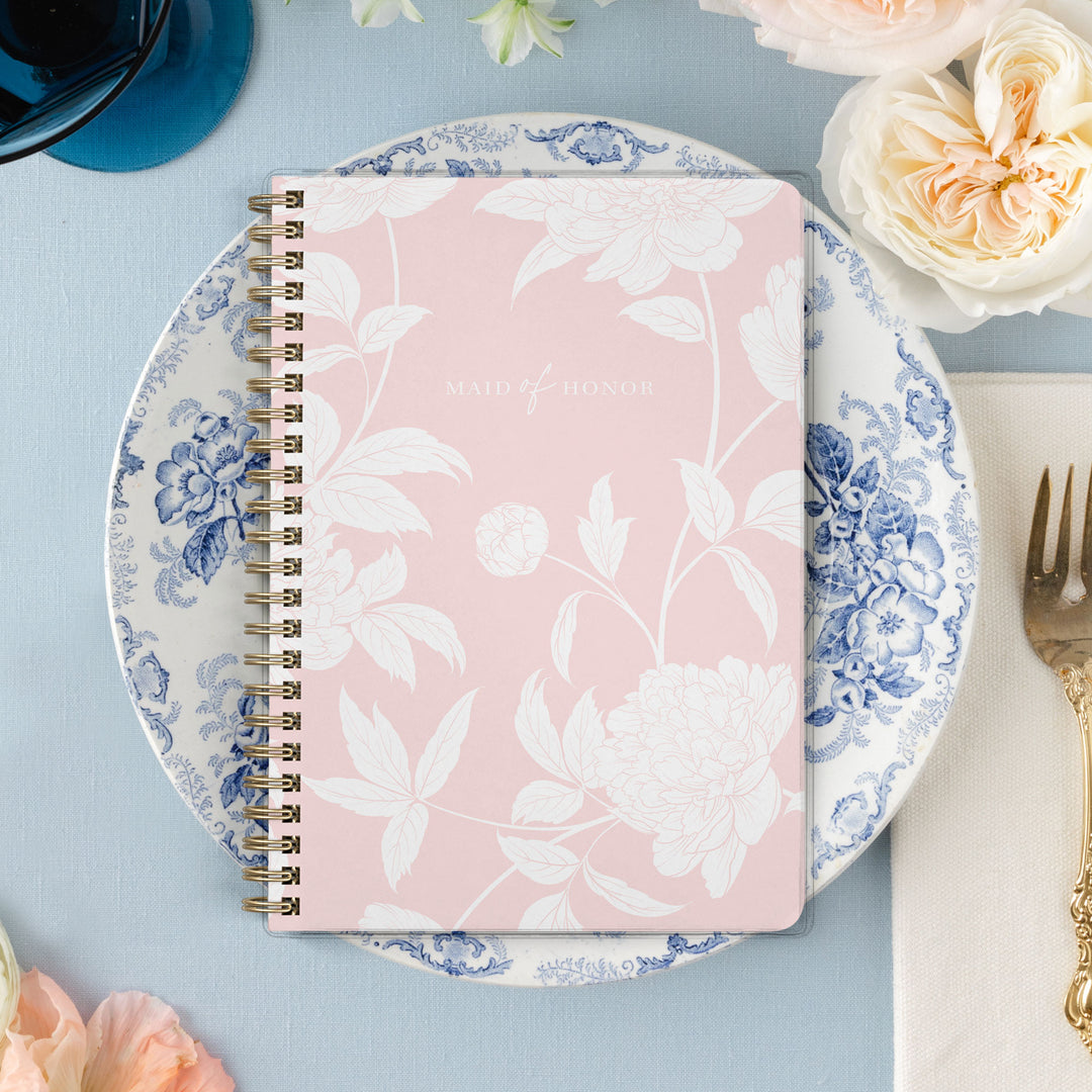 Our exclusive maid of honor planners are the perfect gift for your best friend, shown in a blush peony pattern