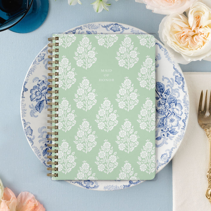 Our exclusive maid of honor planners are the perfect gift for your best friend, shown in a fresh green floral block print