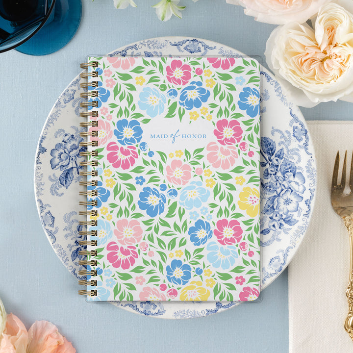 Our exclusive maid of honor planners are the perfect gift for your best friend, shown in a colorful garden floral design.