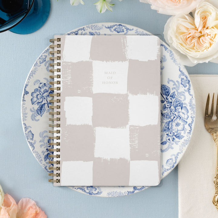 Our exclusive maid of honor planners are the perfect gift for your best friend, shown in a neutral painted checkerboard pattern