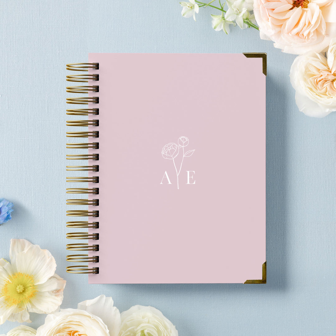 Our luxury wedding planner books are the best a bride can buy, featuring a delicate peony stem with monogram