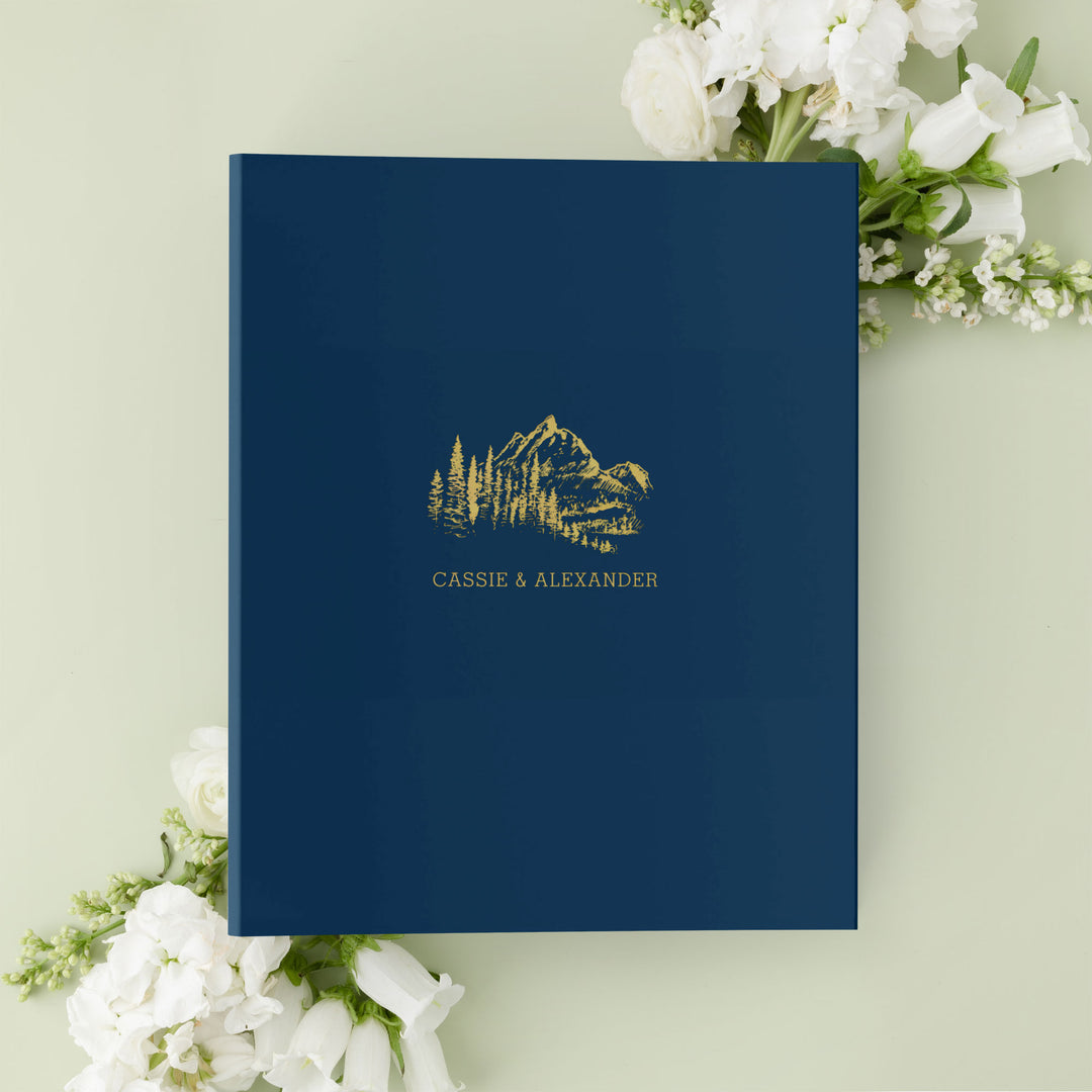 Our wedding binders are the perfect wedding planning tool, shown in a mountain treeline design with the couple's first names