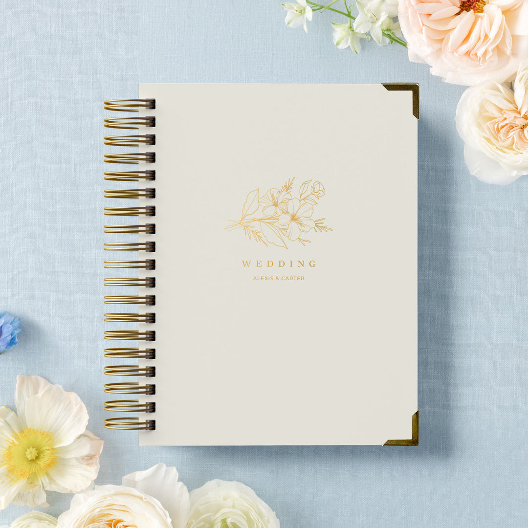 Buku wedding planner terbuka dengan halaman desain bunga